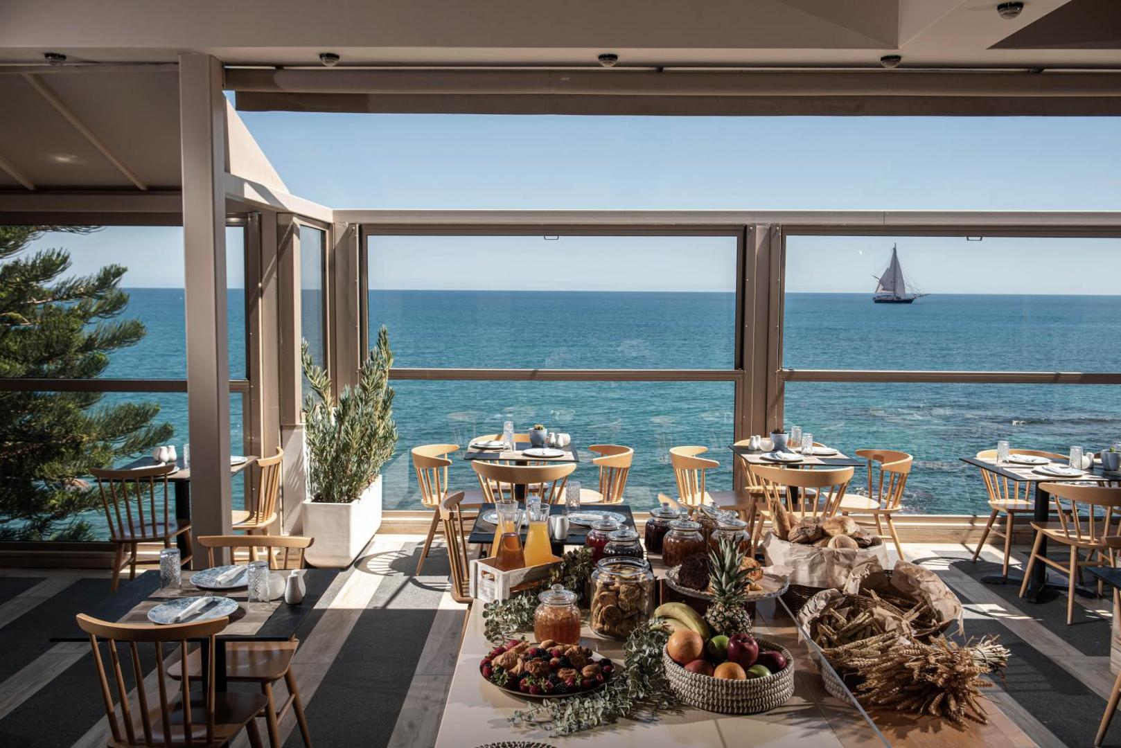 Serenity Spritz Boutique Hotel brokastu bufete uz terases ar skatu uz jūru un buru kuģi piekrastē