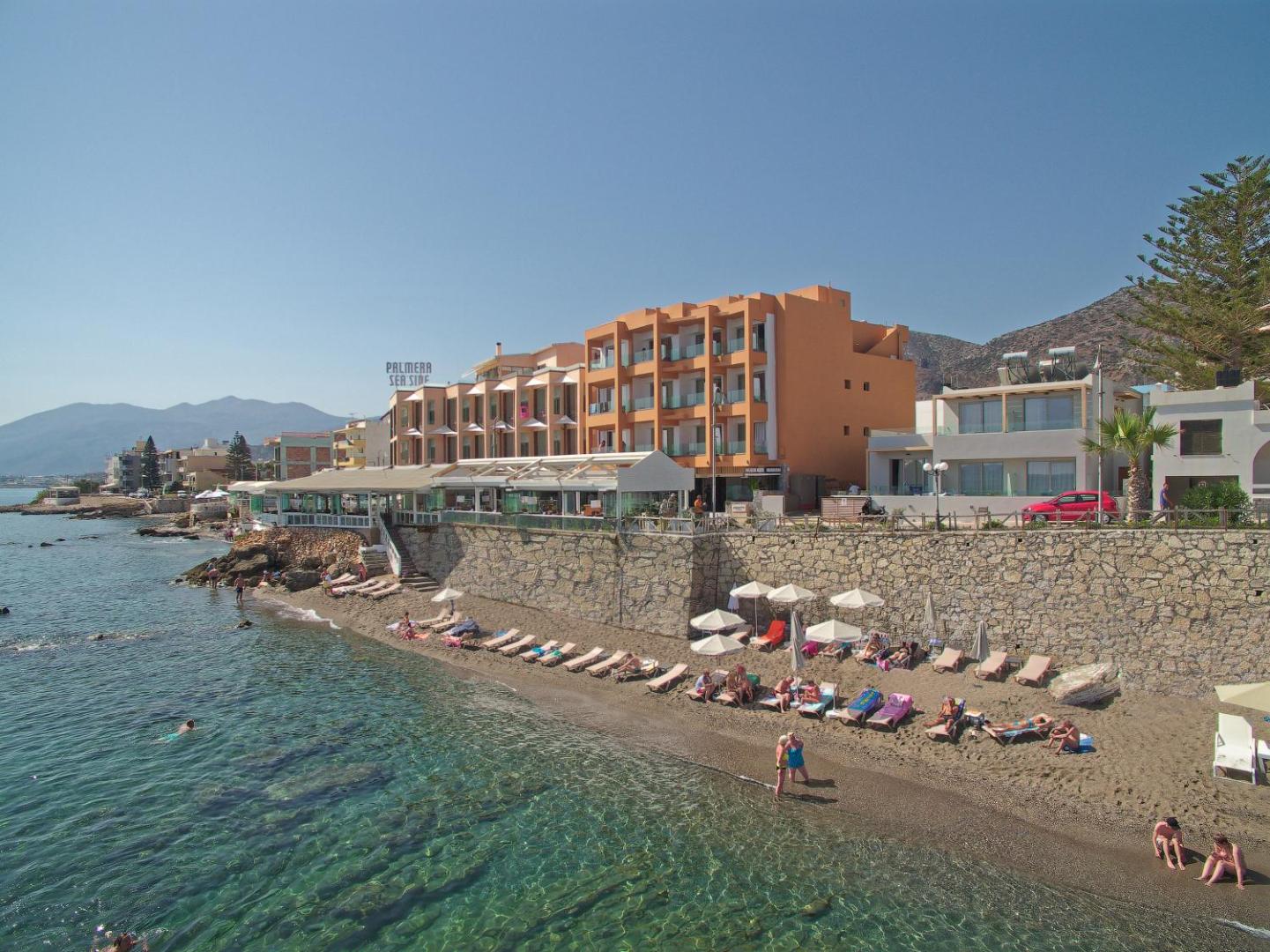 Palmera Beach Hotel & Spa skats no putna lidojuma uz pludmali un viesnīcas ēku Hersonisā — dzidrs ūdens un atpūtas zona
