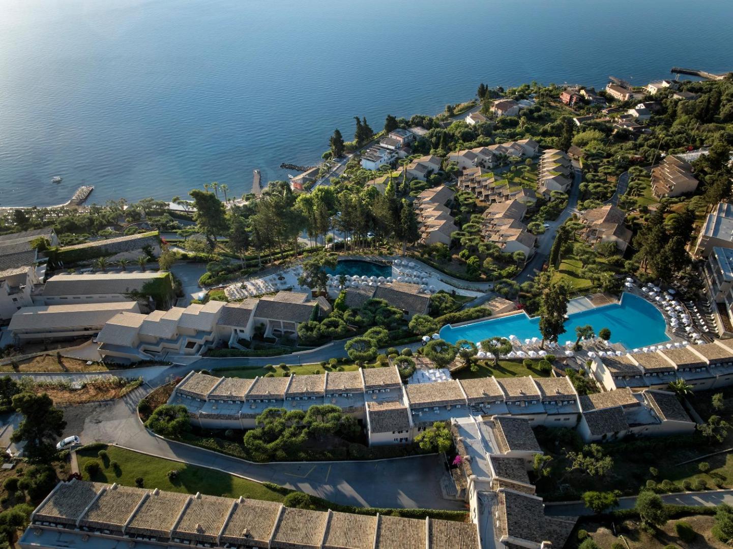 Aeolos Beach Resort panorāmas skats no putna lidojuma Korfu salā — viesnīcas komplekss ar baseiniem un dārziem Jonijas jūras piekrastē