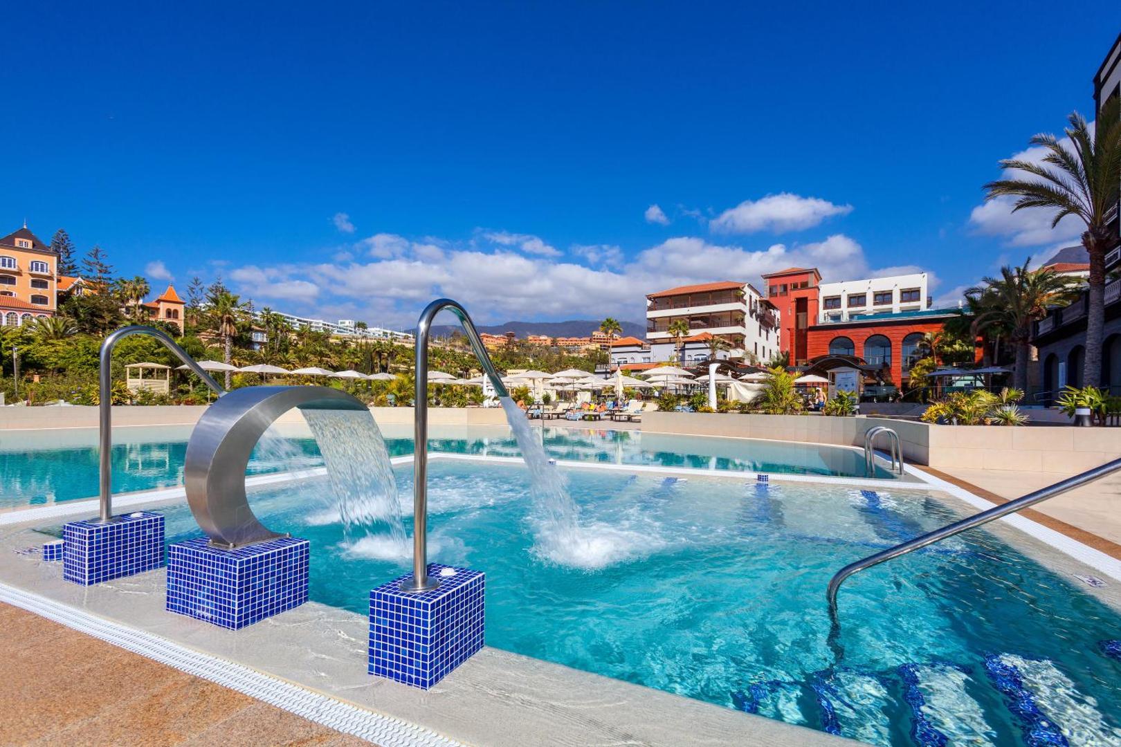 Gran Tacande Wellness & Relax hidromasāžas baseins ar ūdens strūklām un skatu uz viesnīcas teritoriju un kalniem