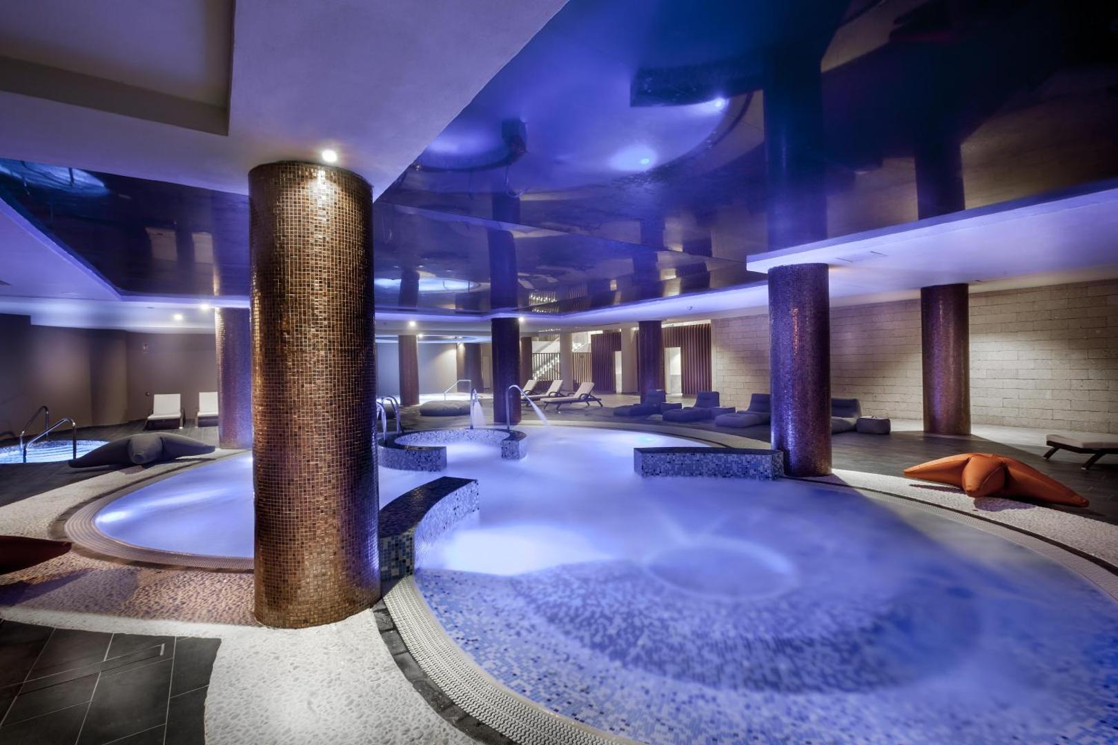 Gran Tacande Wellness & Relax spa centrs ar iekštelpu baseinu, hidromasāžas zonām, siltu apgaismojumu un atpūtas krēsliem Tenerifē.