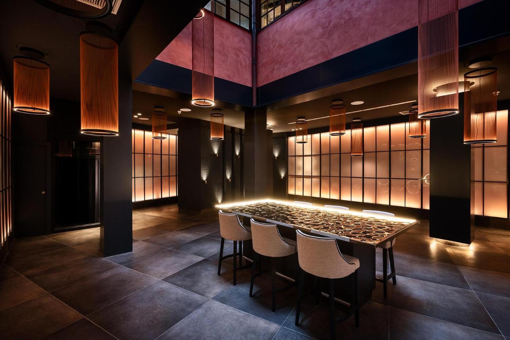 Gran Tacande Wellness & Relax viesnīcas elegants vestibils ar dizaina gaismekļiem, tumšu interjeru un stilīgu bāra zonu Tenerifē.