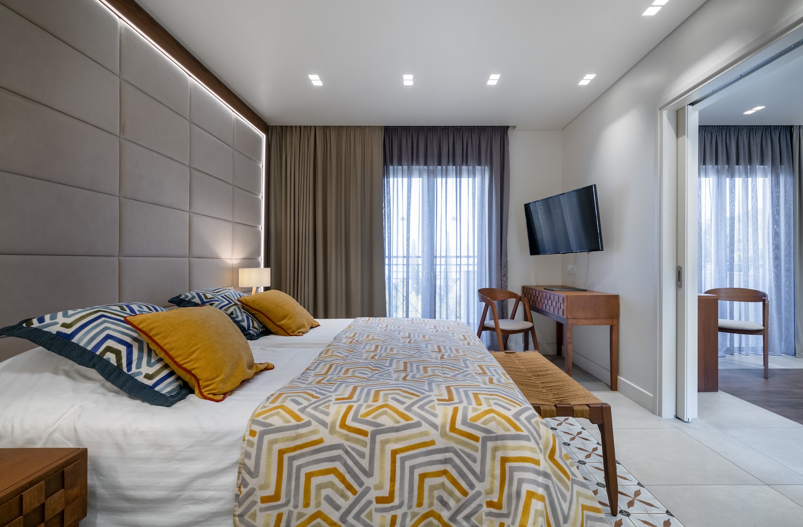 Mareblue Beach Resort moderns numurs ar divguļamo gultu, koka mēbelēm un rakstainu tekstilu Korfu salā, Grieķijā.