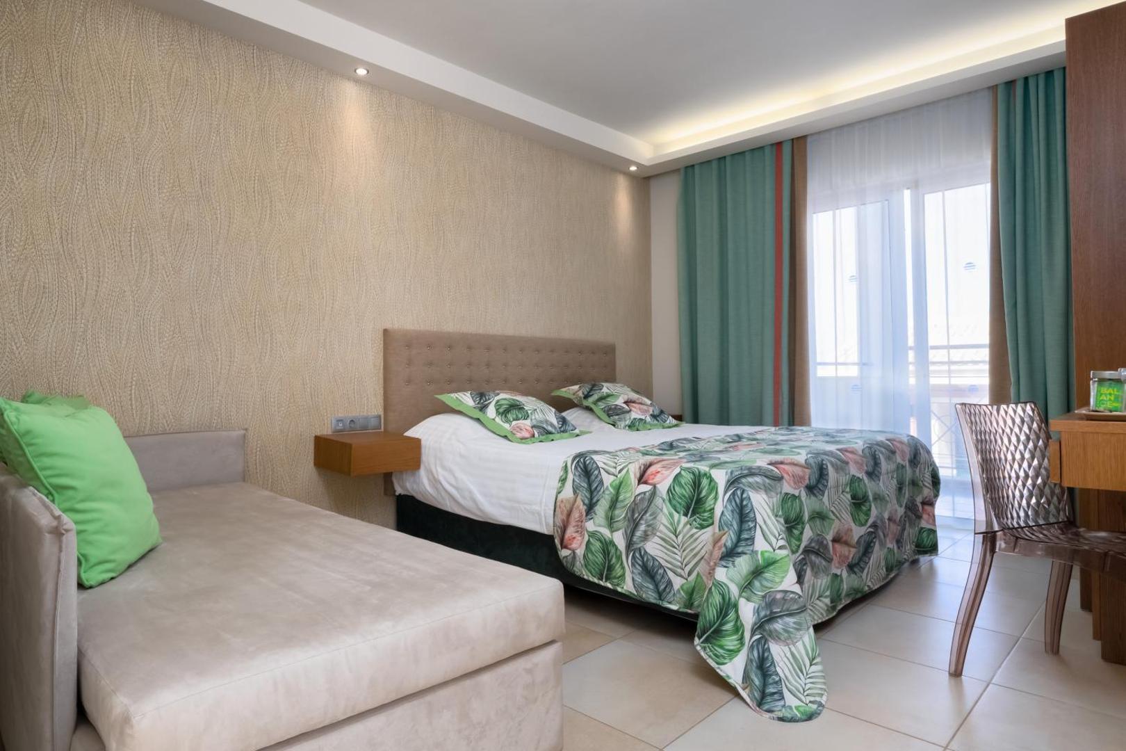 Mareblue Beach Resort numurs ar papildu dīvānu, gaišām sienām un modernu interjeru ģimenes atpūtai Korfu.