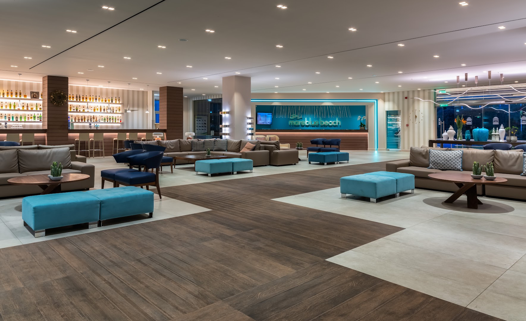 Mareblue Beach Resort plašā lobby zona ar moderniem dīvāniem, bāru un recepcijas leti Korfu salas kūrortā.