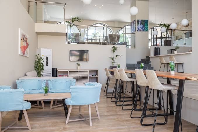 Golden Mare Barbati viesnīcas lobby bārs un atpūtas zona ar gaišām mēbelēm, augstiem krēsliem un modernu interjeru