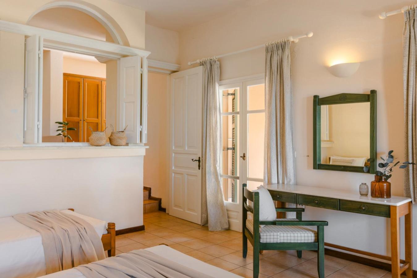 Century Resort Hotel gaišs numurs ar divām gultām, koka mēbelēm, rakstāmgaldu un dekoratīvām detaļām grieķu stilā