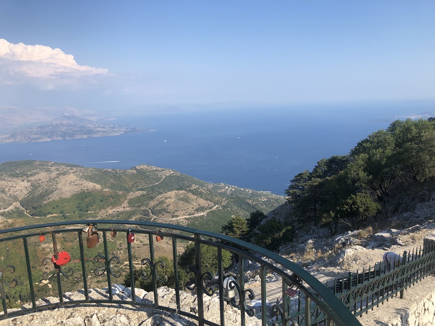 Skatu laukums ar metāla margām un piekaramajām atslēgām Pantokrator kalna virsotnē ar plašu skatu uz Jonijas jūru