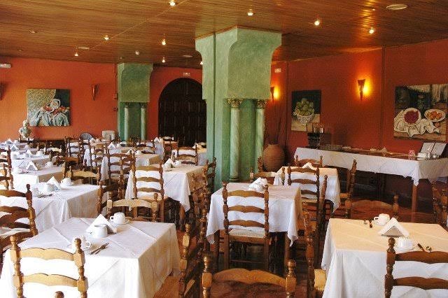 Paradise Corfu restorāna iekštelpas ar klasiskām koka mēbelēm, baltiem galdautiem un siltu apgaismojumu tradicionālā grieķu stilā