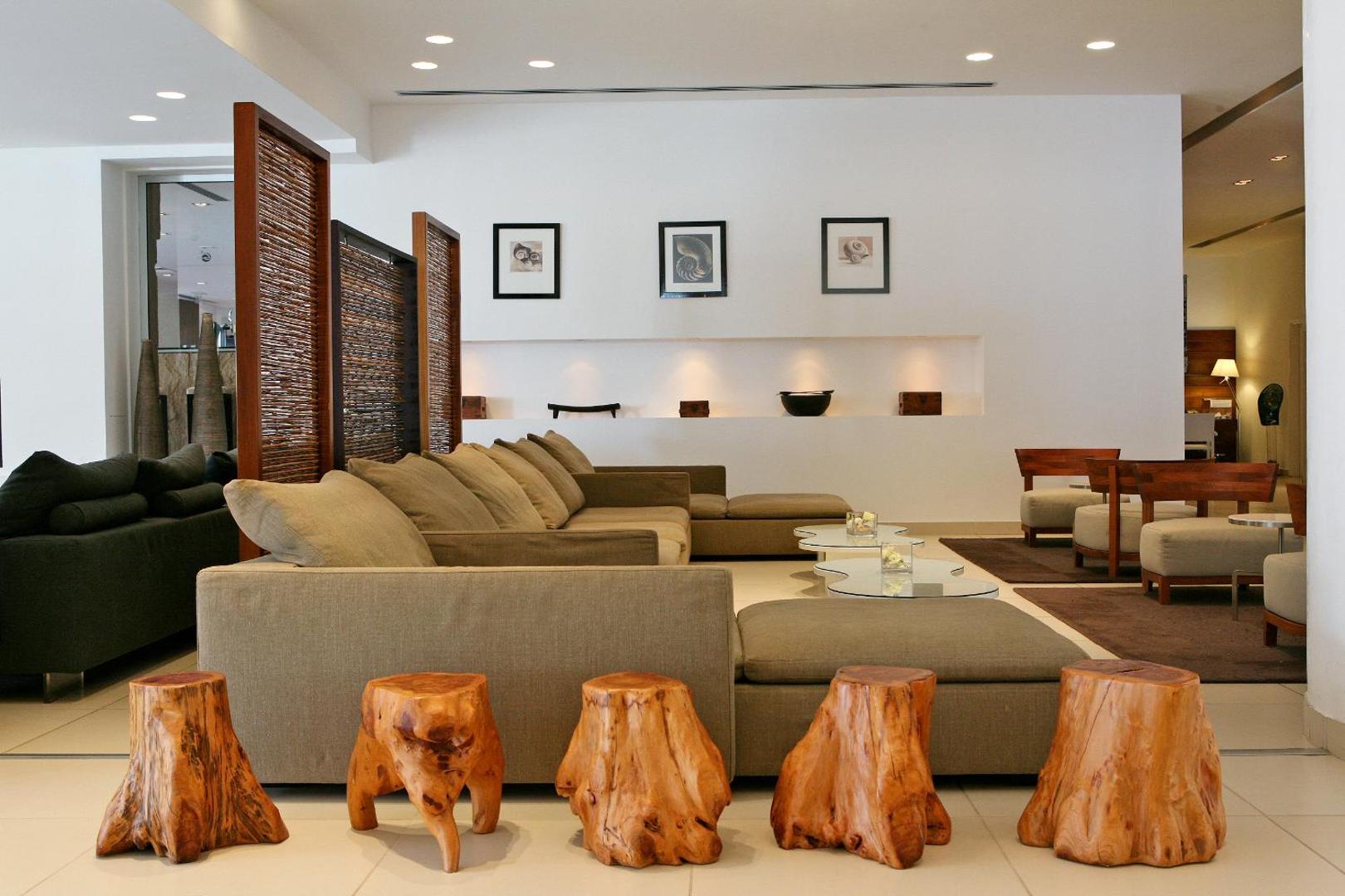 Napa Mermaid Hotel lobby atpūtas telpa ar moderniem dīvāniem un koka dizaina elementiem Ajanapā, Kiprā