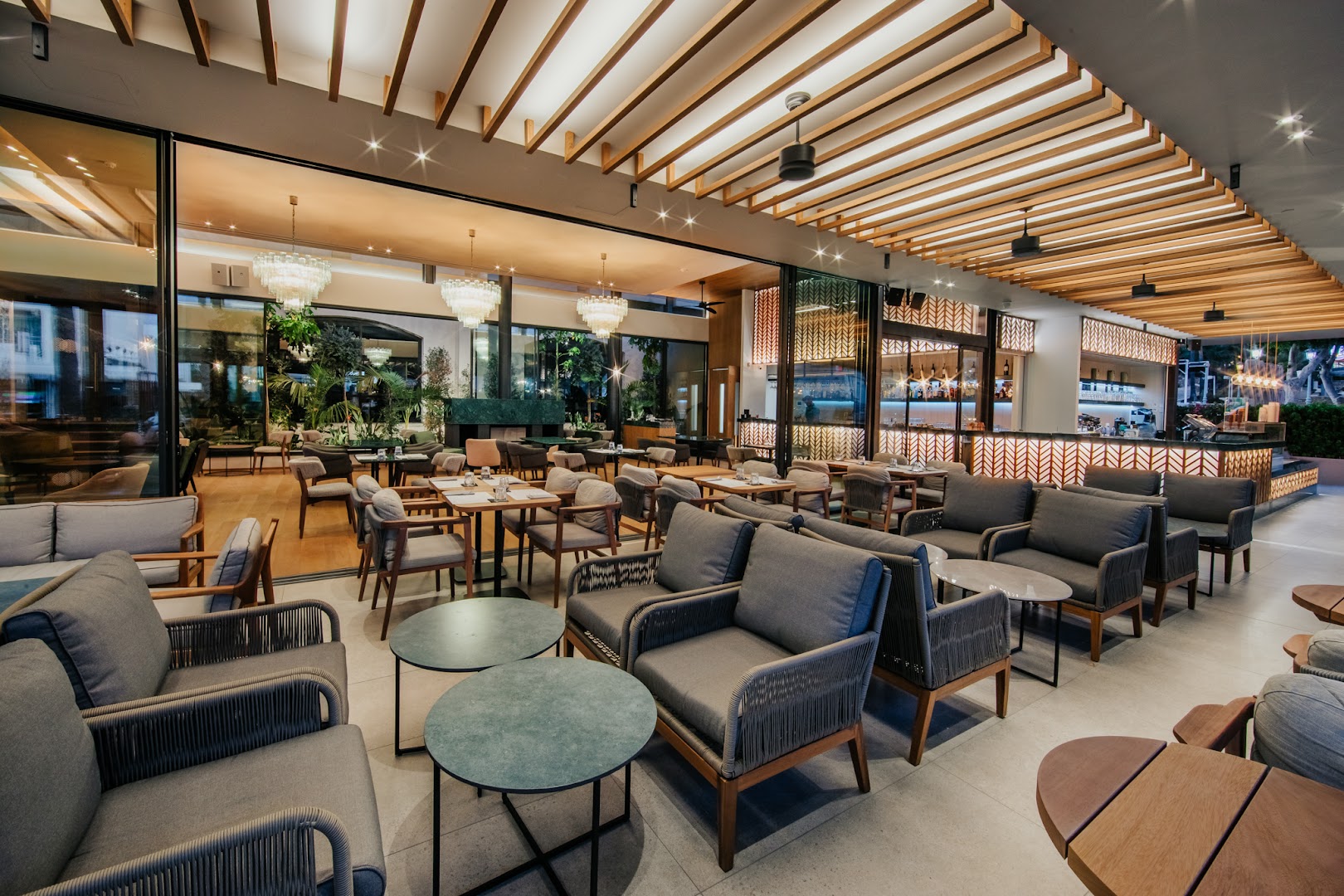 Napa Plaza viesnīcas modernā atpūtas telpa un bārs ar mīkstajiem krēsliem, dizaina lustrām un koka griestu elementiem
