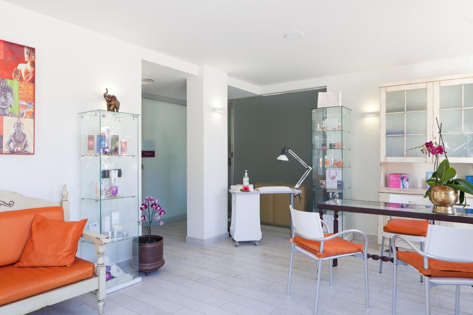 Gaiša Hotel Colon Guanahani skaistumkopšanas un procedūru telpa ar modernu interjeru, oranžiem akcentiem un vitrīnām Tenerifē