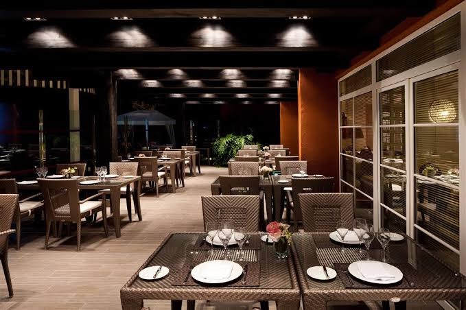 Sol Barbacan Aparthotel restorāna iekštelpas ar klātiem galdiem un pītiem krēsliem vakarā — elegants apgaismojums un mājīga atmosfēra Grankanārijā