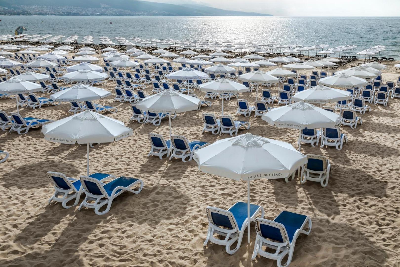 Melia Sunny Beach Resort pludmales zona ar rindu kārtībā izvietotiem saulessargiem un ērtiem sauļošanās krēsliem smilšainā piekrastē