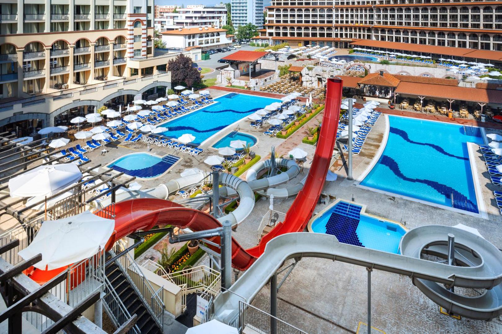 Melia Sunny Beach Resort akvaparka zona ar sarkaniem un pelēkiem ūdens slidkalniņiem un bērnu baseiniem Saulainā krasta kūrortā