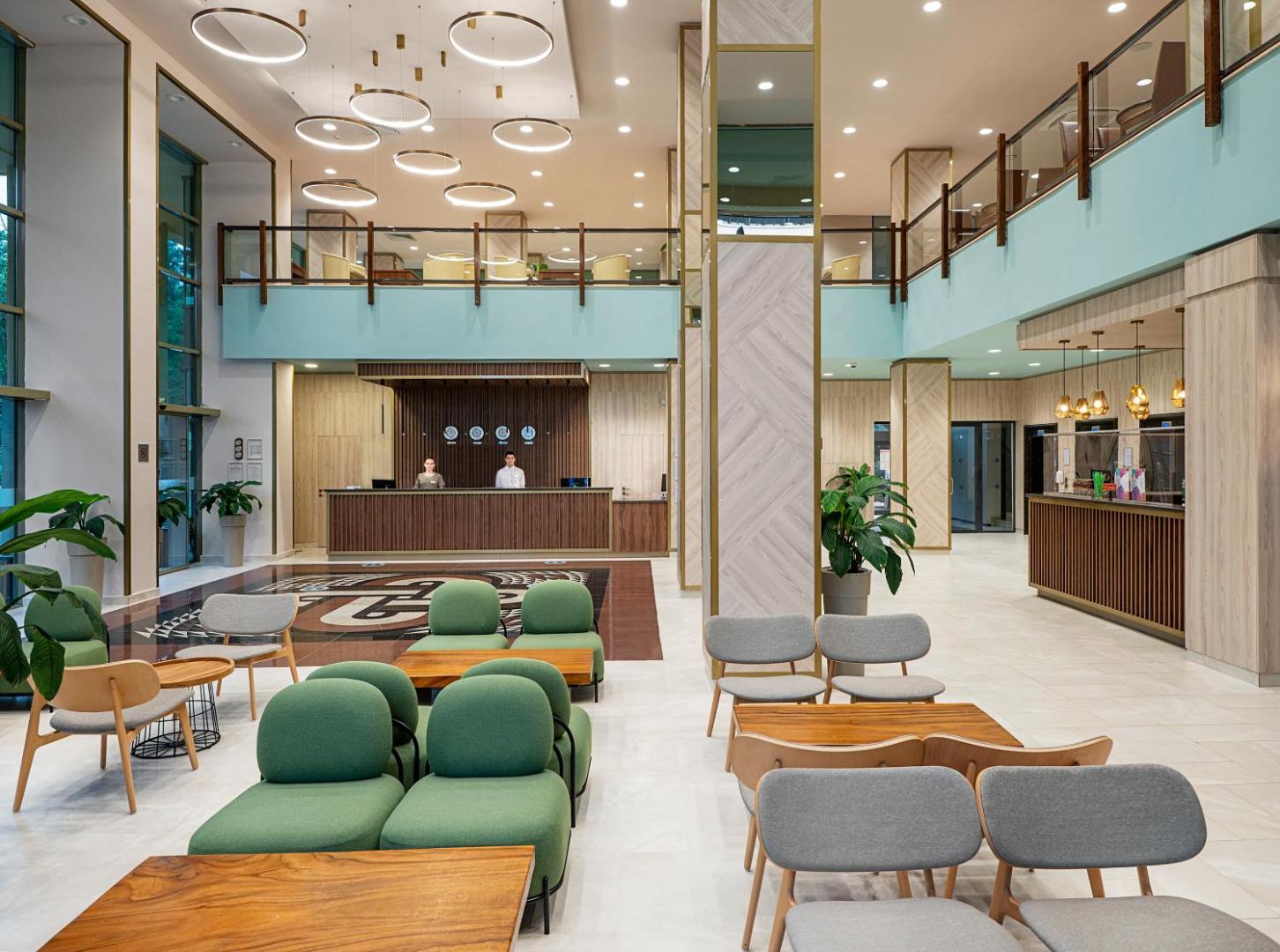 Melia Sunny Beach Resort modernā lobby zona ar augstiem griestiem, stilīgām mēbelēm, recepciju un dekoratīviem gaismas ķermeņiem
