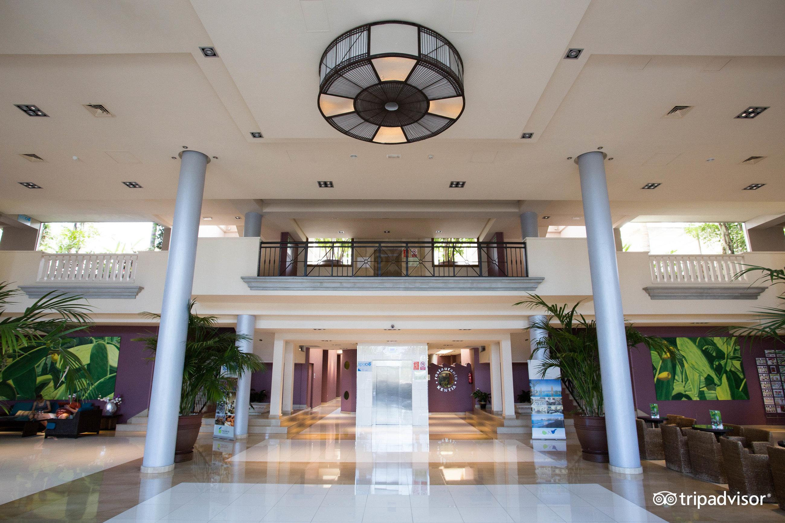 Marylanza Suites & Spa iekštelpu vestibila skats uz liftu zonu un atpūtas stūrīšiem ar modernām mēbelēm un dekoratīviem augiem.