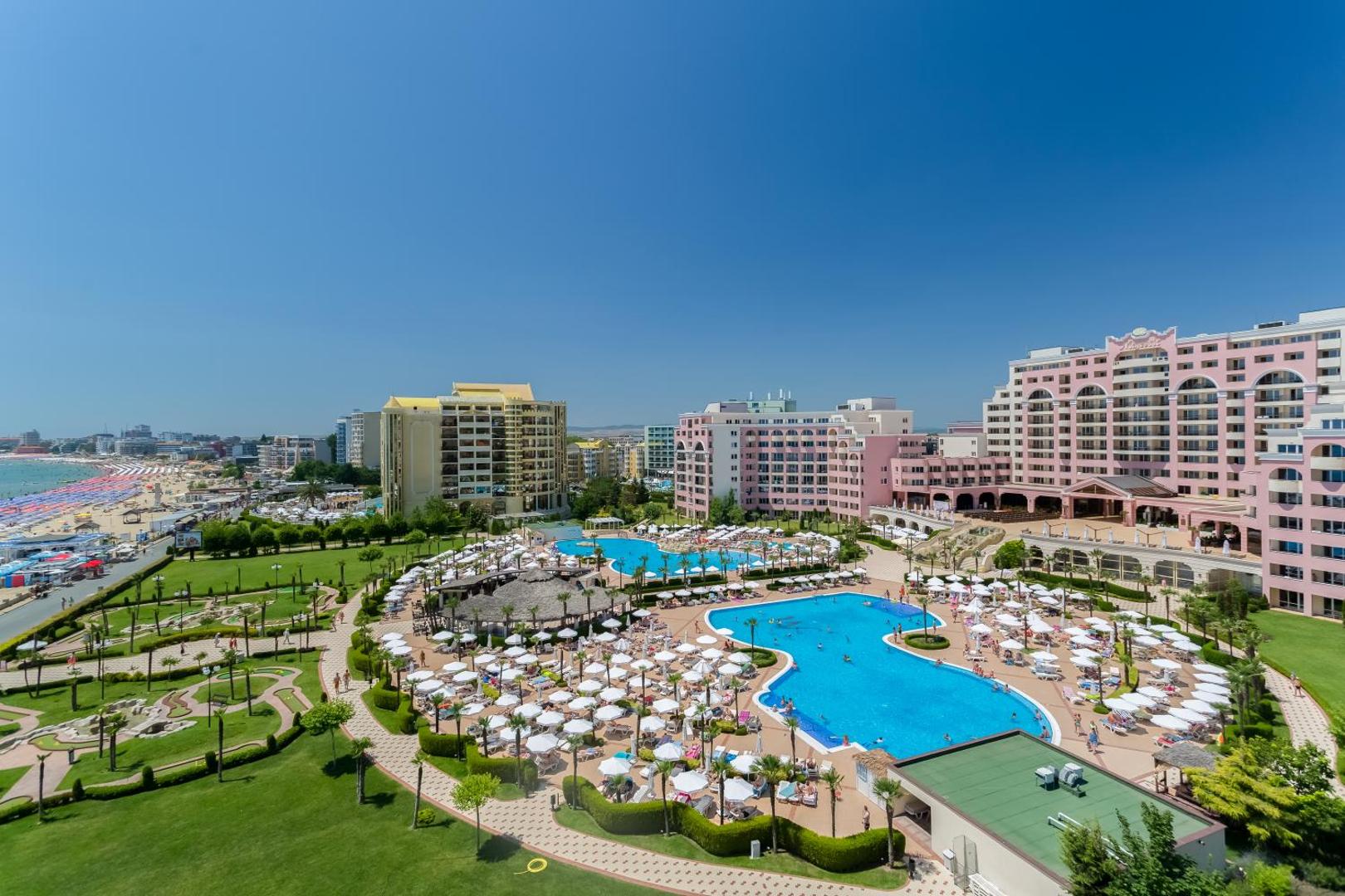 DIT Majestic Beach Resort viesnīcas ēkas fasāde un plašā teritorija ar baseiniem, zālieniem un atpūtas zonām pie jūras