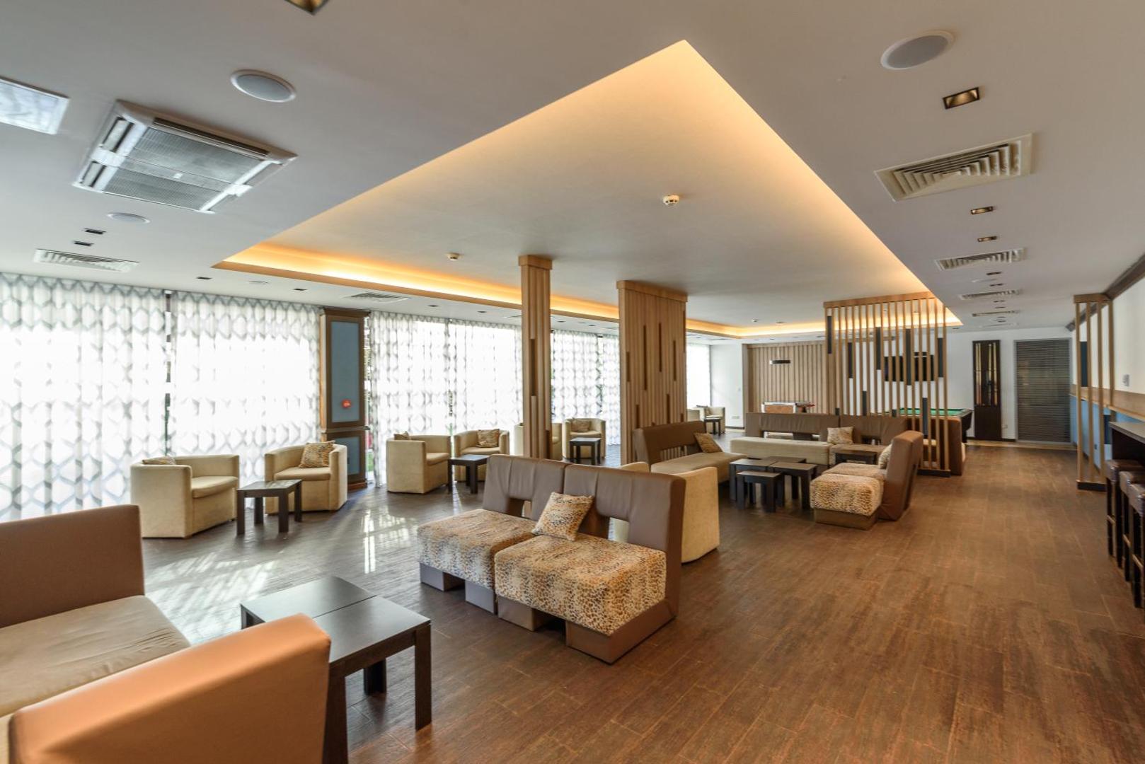 Lion Sunny Beach Hotel lobby bārs un atpūtas zona ar mīkstajiem dīvāniem, atpūtas krēsliem un koka apdari