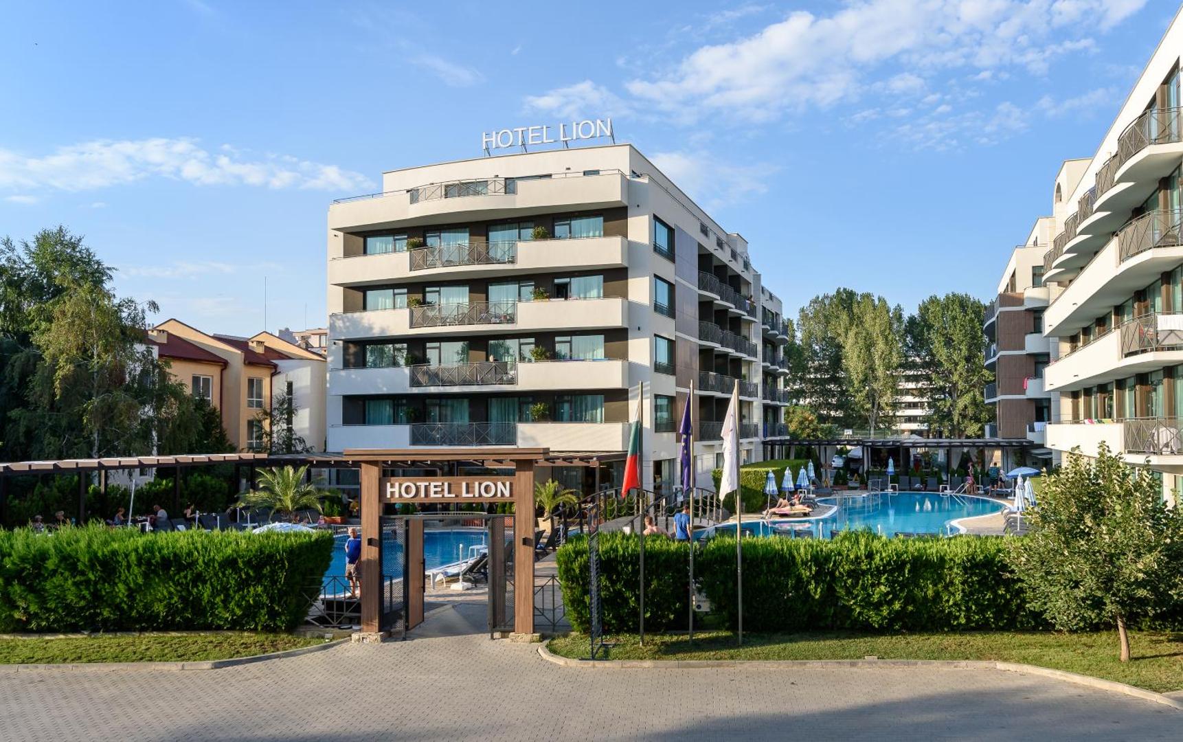 Ieeja Lion Sunny Beach Hotel teritorijā ar skatu uz galveno ēku, baseinu un atpūtas zonu saulainā dienā