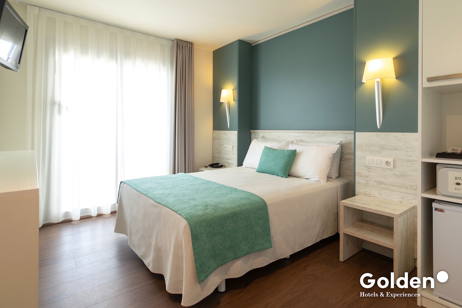 Golden Donaire Beach moderns viesnīcas numurs ar lielu logu un gaišu interjeru Kostadoradas piekrastē, Spānijā.