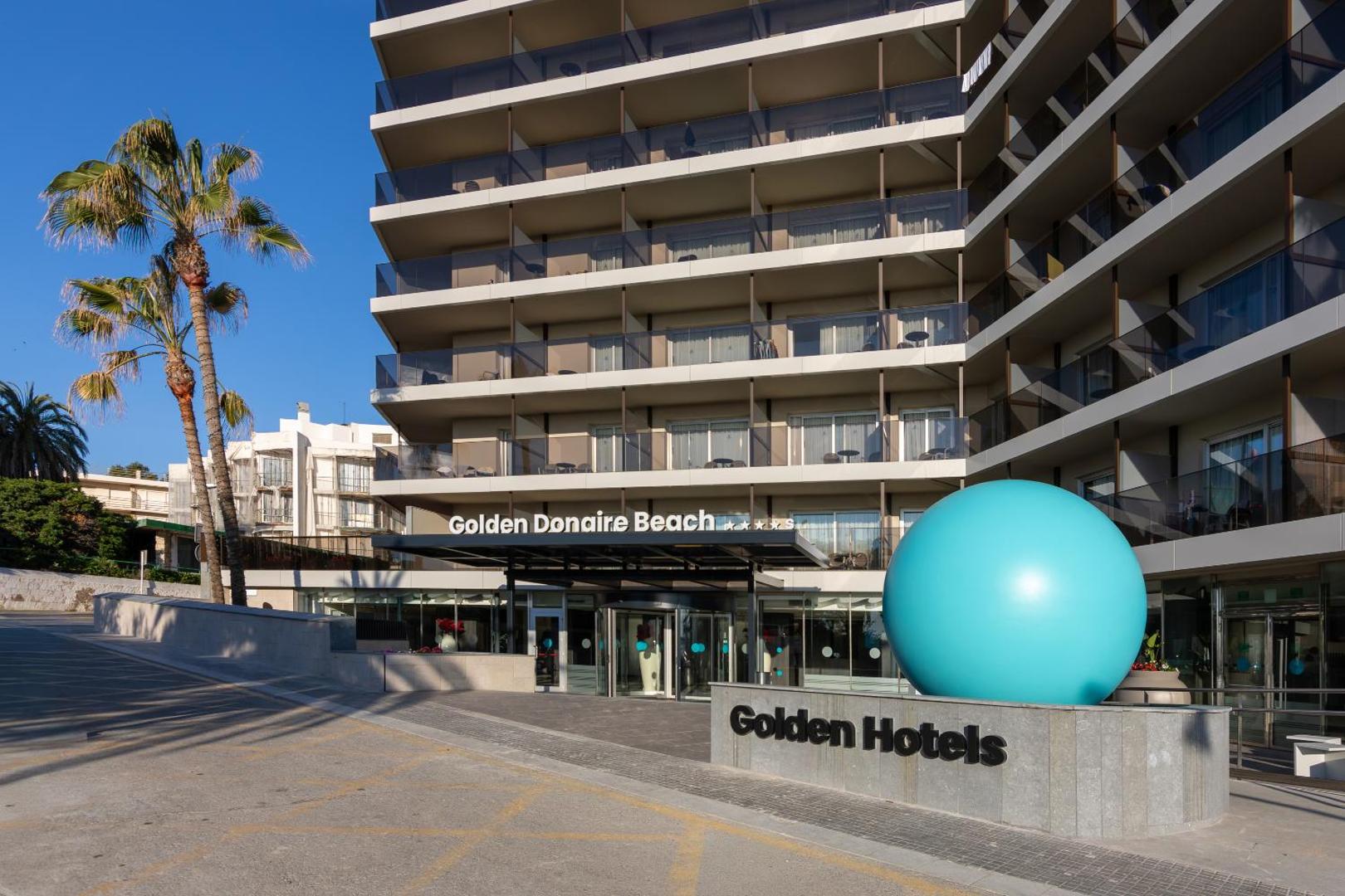 Golden Donaire Beach viesnīcas galvenā ieeja ar zilu dekoratīvu lodi un palmu Kosta Doradā, Spānijā.