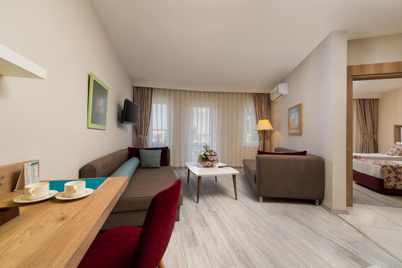 The Garden Beach Hotel ģimenes numura viesistabas zona ar dīvāniem, kafijas galdiņu un atsevišķu guļamistabu
