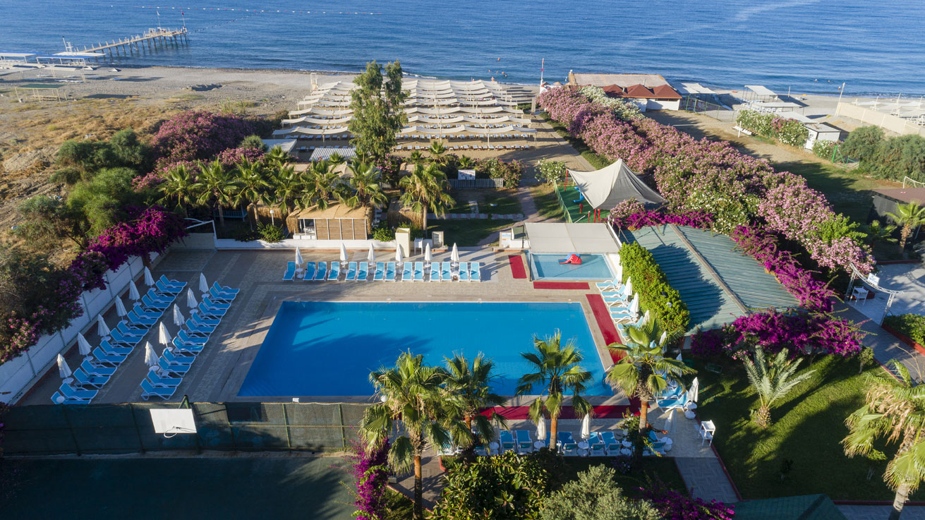 The Garden Beach Hotel aerofotoattēls ar āra baseinu, sauļošanās zonu un privāto pludmali Konakli reģionā, Turcijā — apkārt ziedoši dārzi un palmas