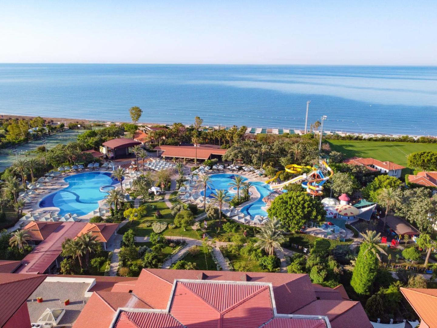Belconti Resort Hotel panorāmas skats Belekā — plaša teritorija ar baseiniem, akvaparku un tiešu pieeju Vidusjūras smilšu pludmalei