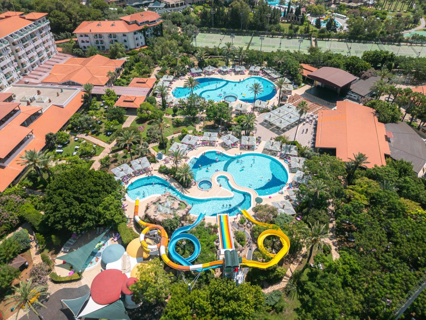 Belconti Resort Hotel aerofoto ar lieliem baseiniem, krāsainiem ūdens slidkalniņiem un plašu apzaļumotu teritoriju Belekā, Turcijā