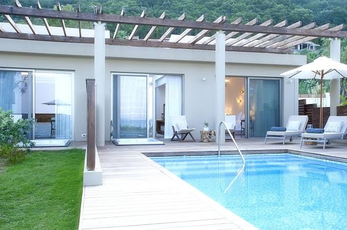 Domes Miramare Resort eleganti numuri ar izeju uz baseinu un koka terasi — skats uz viesnīcas fasādi un dārzu