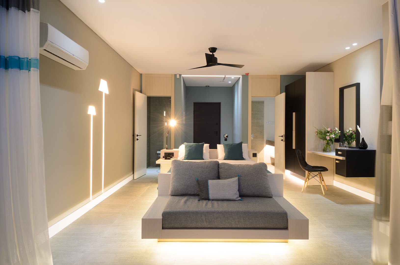 Domes Aulus Elounda Resort plašs suite numurs ar dzīvojamo zonu, modernu apgaismojumu un minimālisma stila mēbelēm