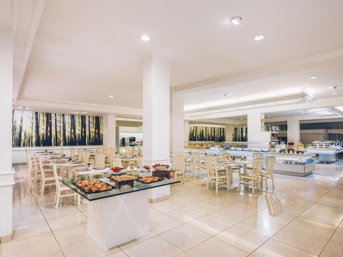 Iberostar Waves Las Dalias plašā un gaišā restorāna zāle ar servētiem galdiem un bufetes zonu fonā — mūsdienīgs interjers Tenerifē