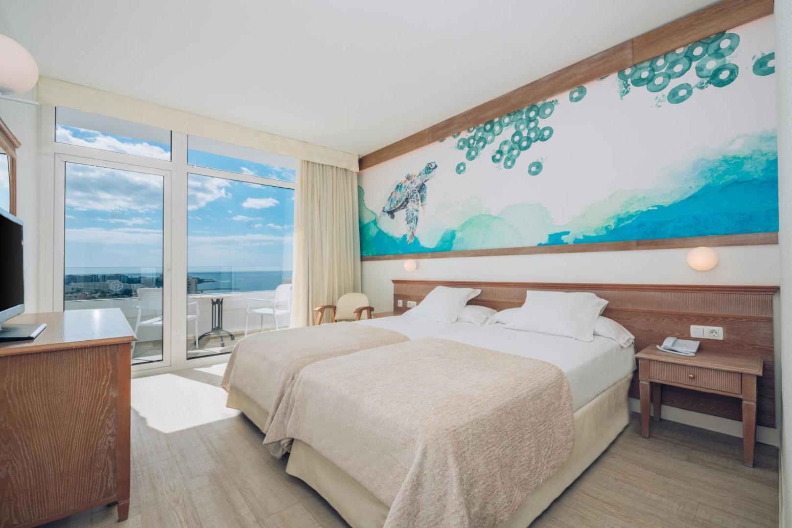 Iberostar Waves Las Dalias gaišs viesnīcas numurs ar divguļamo gultu, sienas dekoru un balkonu ar skatu uz okeānu Tenerifē
