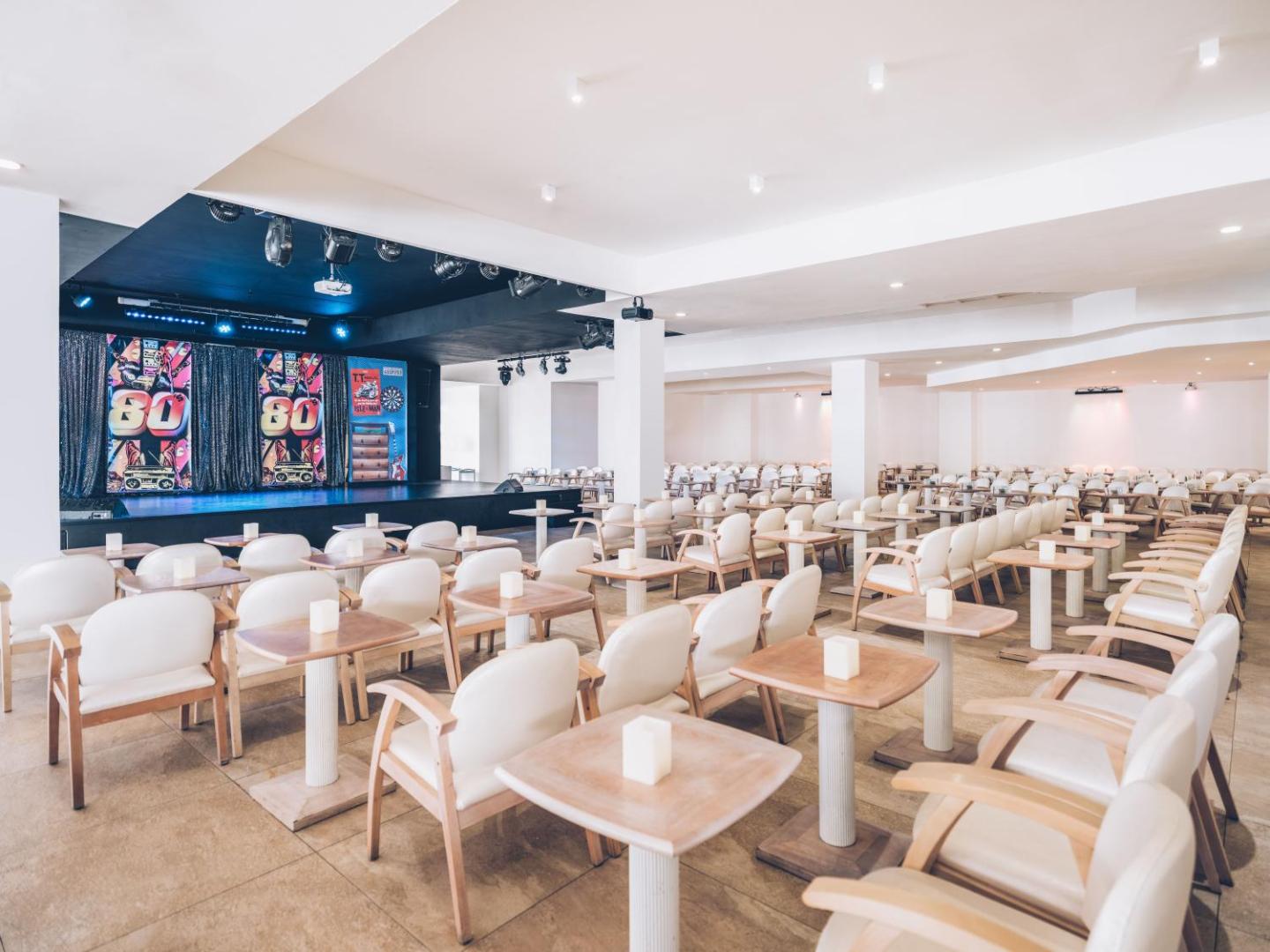 Iberostar Waves Las Dalias pasākumu zāle ar skatuvi un galdiņiem — plaša telpa vakara izklaides programmām un šoviem Tenerifes kūrortā