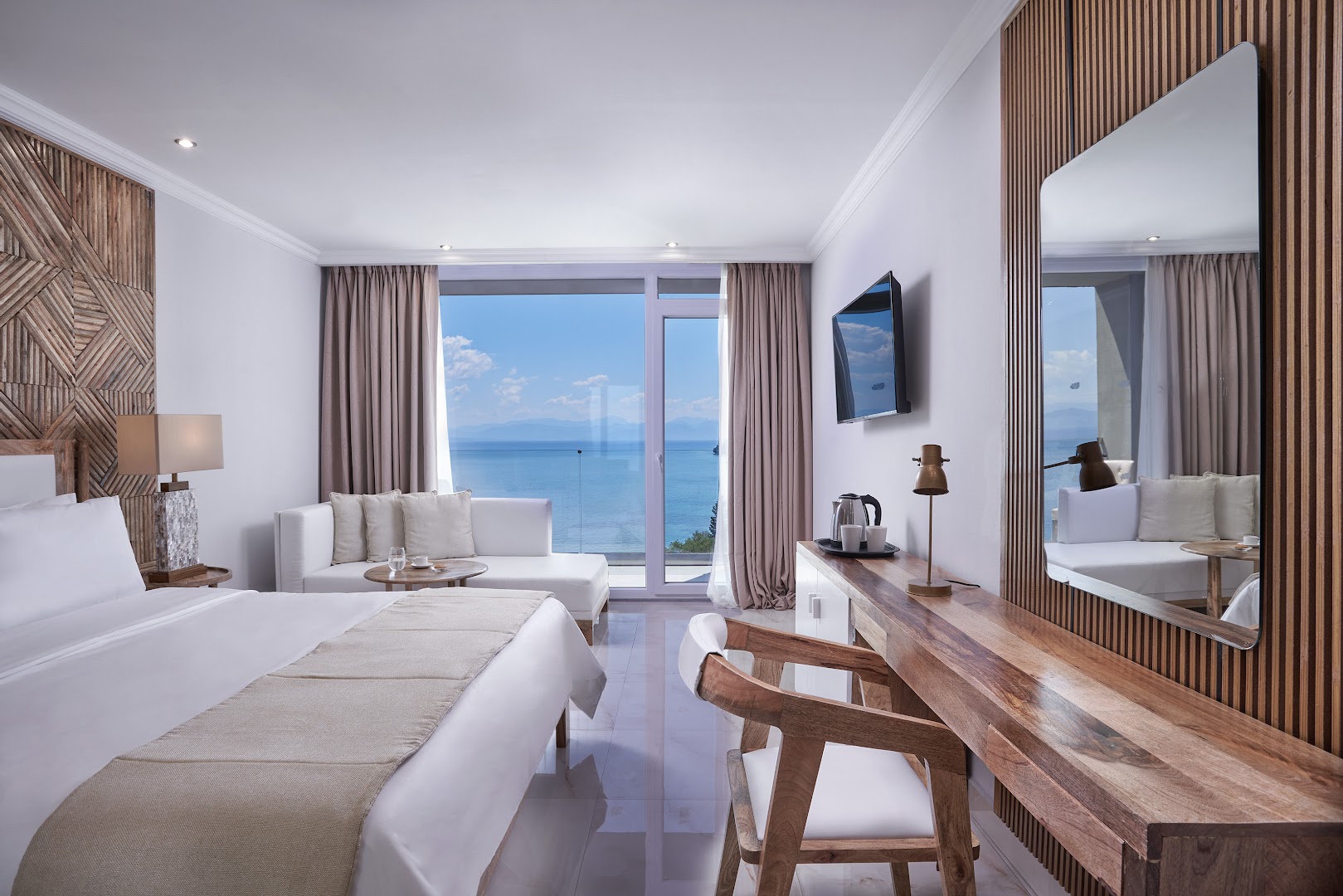 Moderns Mythos Palace Resort numurs ar gaišu interjeru, koka elementiem un plašu balkonu ar skatu uz jūru