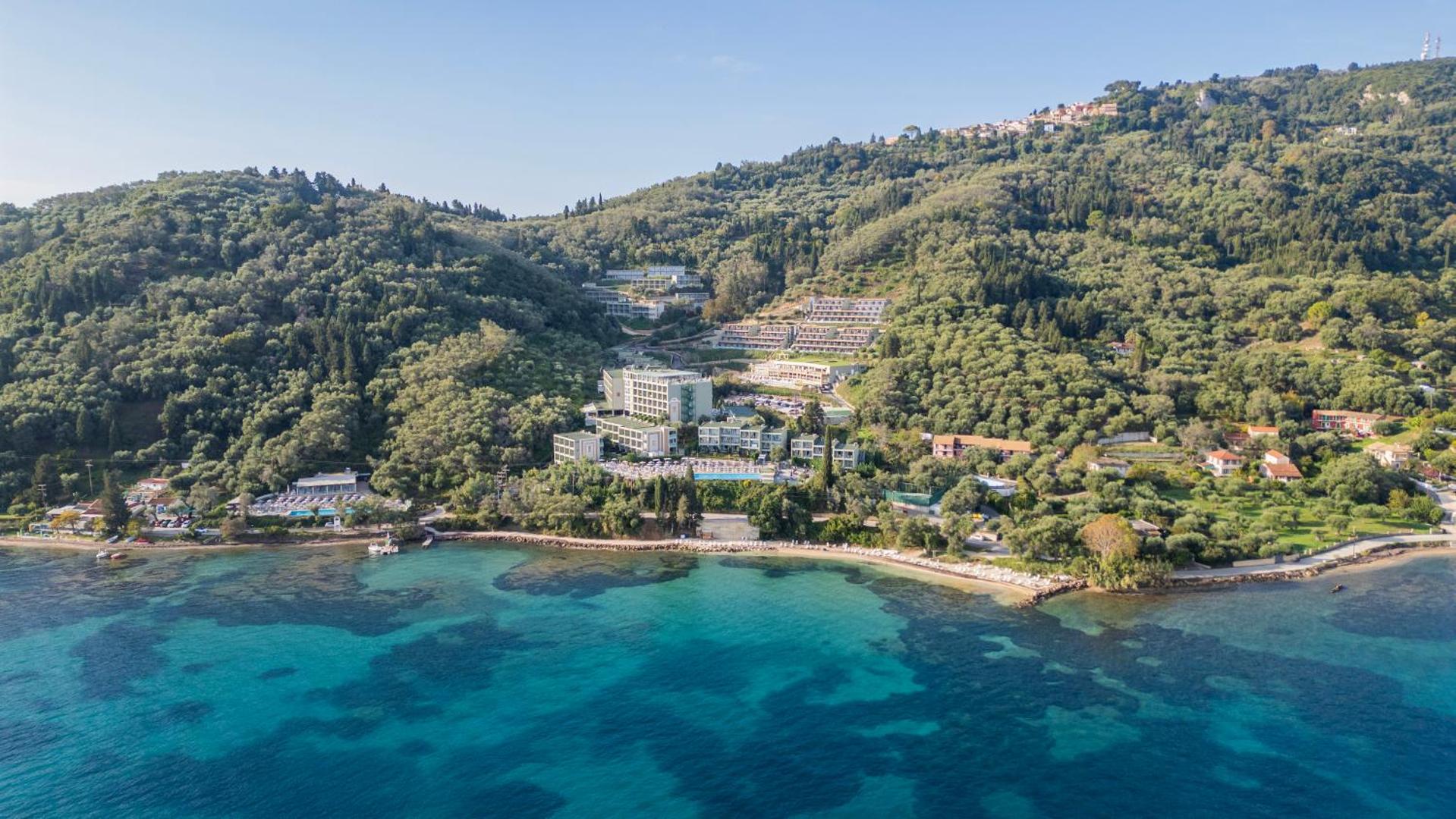 Aerofoto ar Mythos Palace Resort atrašanās vietu Korfu piekrastē — viesnīca atrodas tieši pie dzidri zila līča ūdeņiem