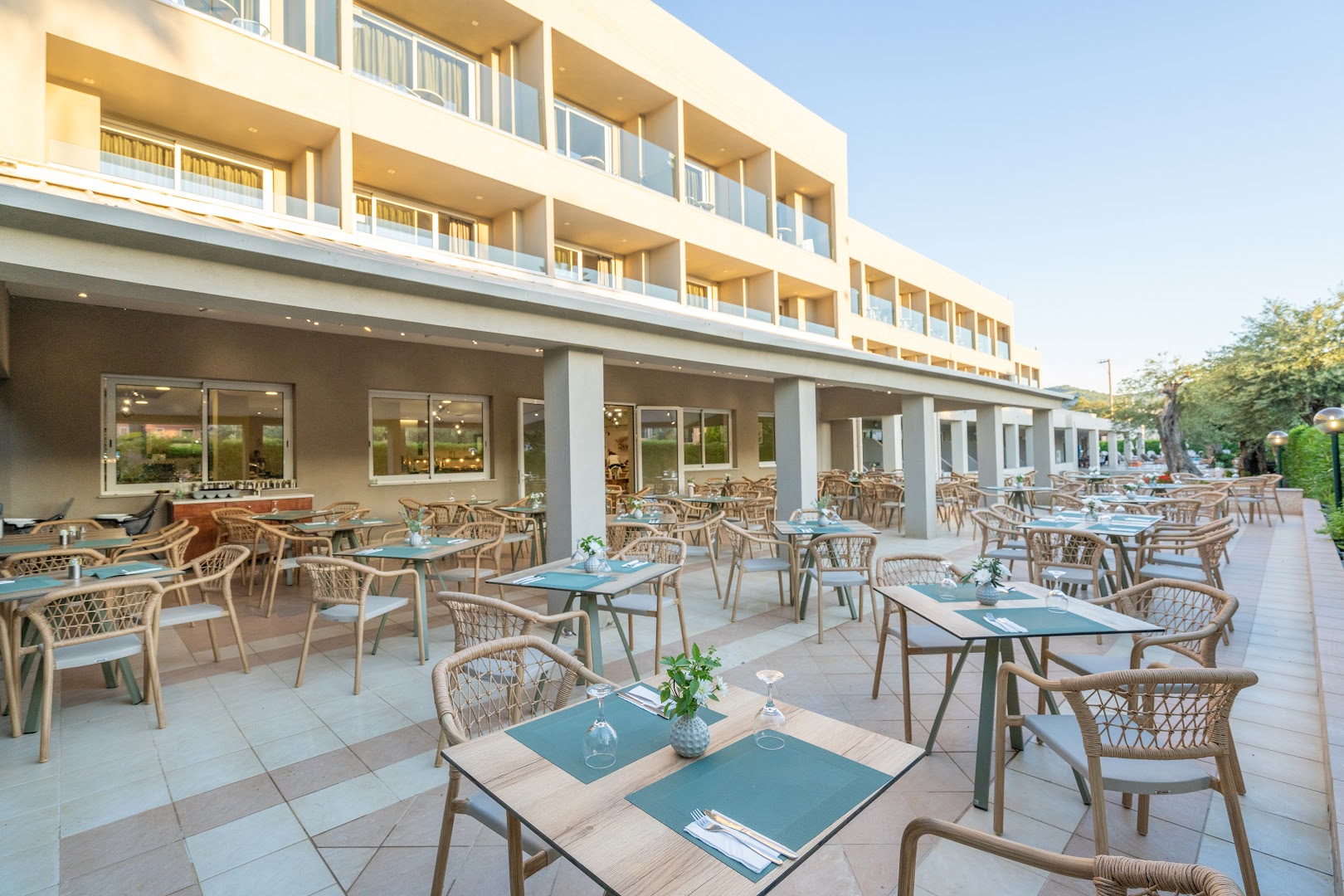 CNic Gemini Hotel āra terase ar pītiem krēsliem un galdiņiem pie viesnīcas ēkas fasādes Mesongi, Korfu