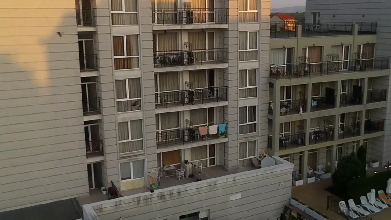 Festa Pomorie Resort numuru balkoni un viesnīcas fasādes fragments vakara saules gaismā