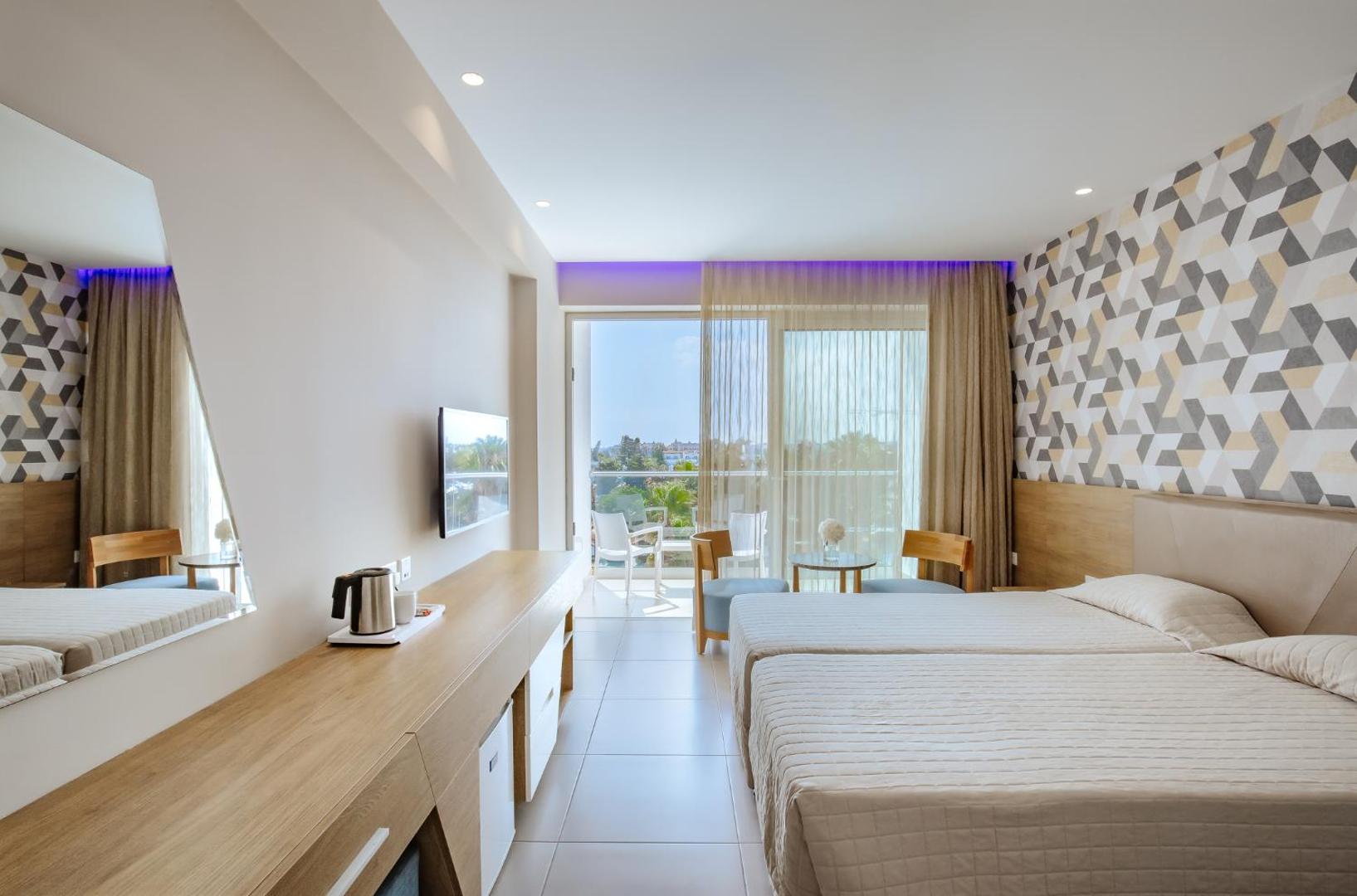 Tasia Maris Seasons Hotel gaišs divvietīgs numurs ar balkonu, koka mēbelēm un modernu sienas dekoru Ajanapā