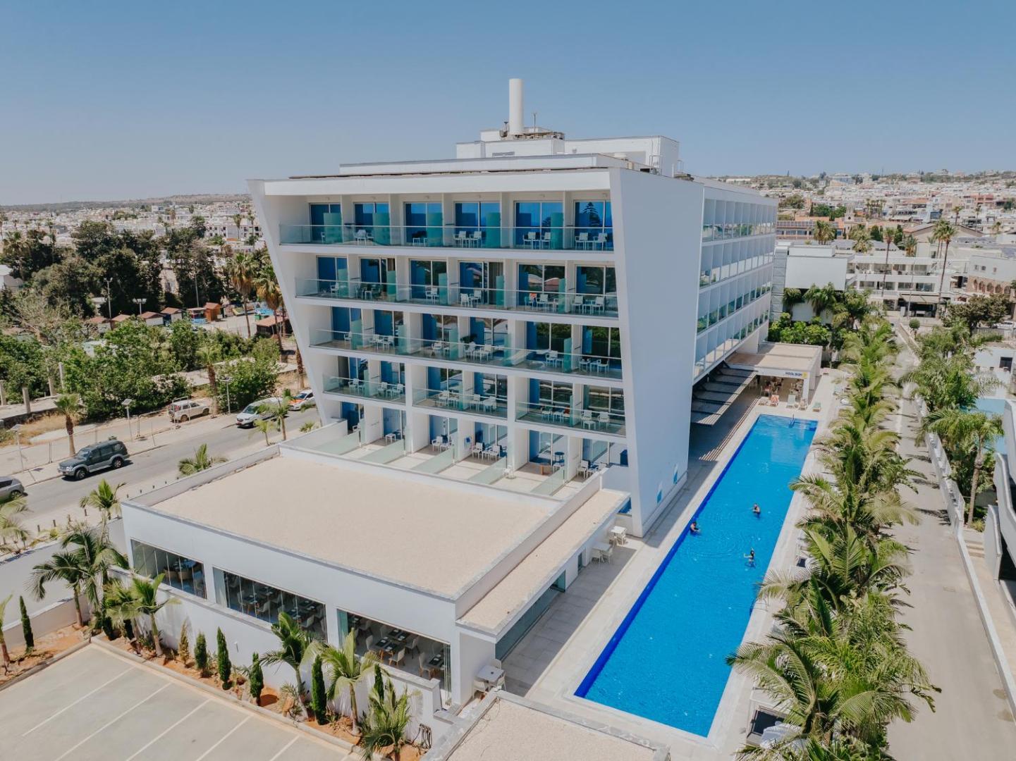 Tasia Maris Seasons Hotel skats no augšas uz āra baseinu un viesnīcas korpusu Ajanapā — palmas un sauļošanās zona