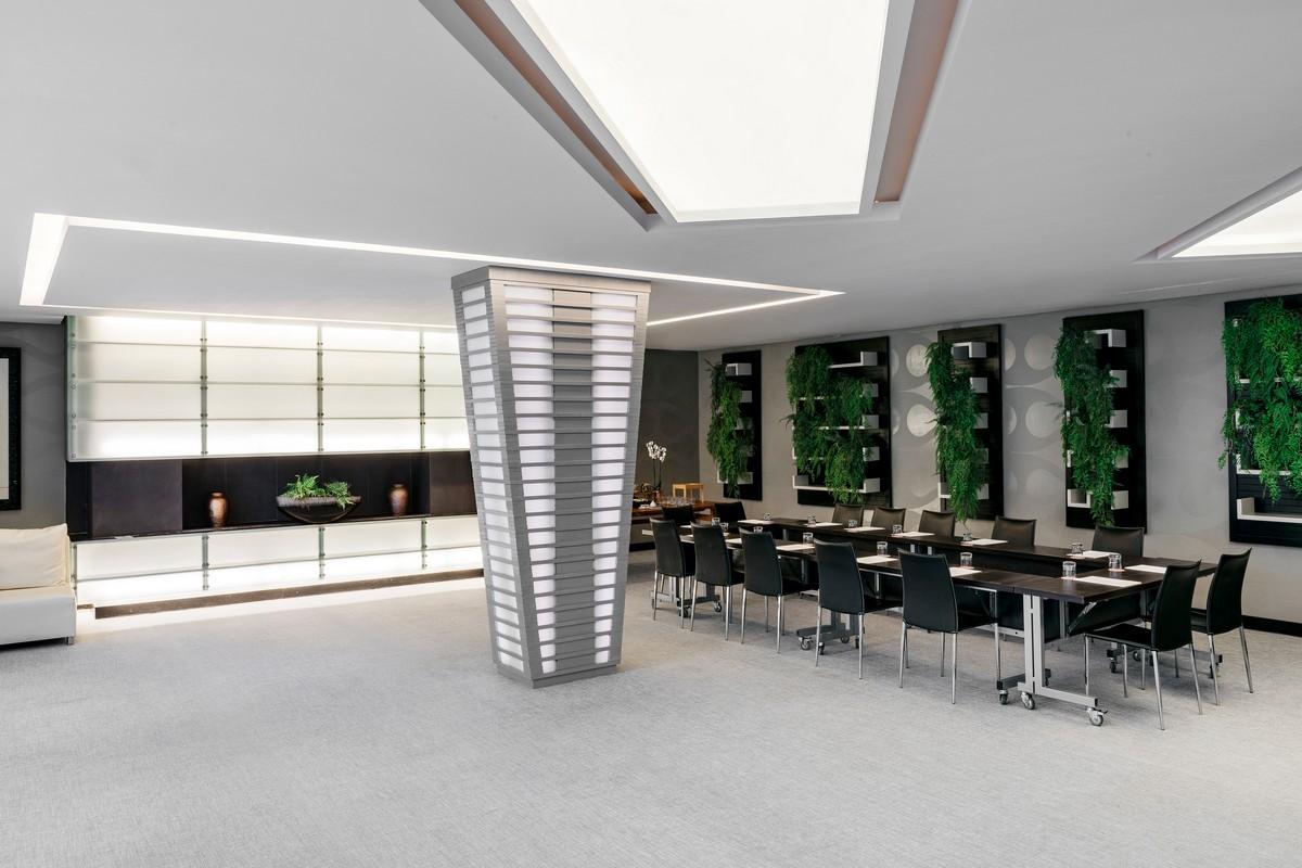 Gran Melia Palacio de Isora konferenču zāle ar melniem krēsliem, U-veida galdu izkārtojumu un modernu apgaismojumu biznesa pasākumiem.