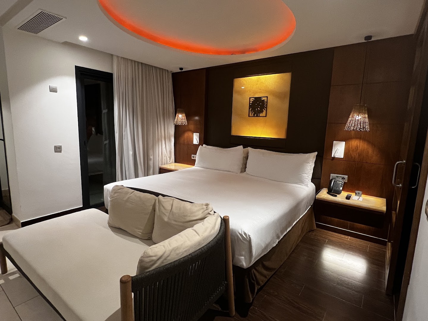 Gran Melia Palacio de Isora luksusa numurs ar lielu gultu, atpūtas dīvānu un siltu apgaismojumu Tenerifes piekrastē, Spānijā.