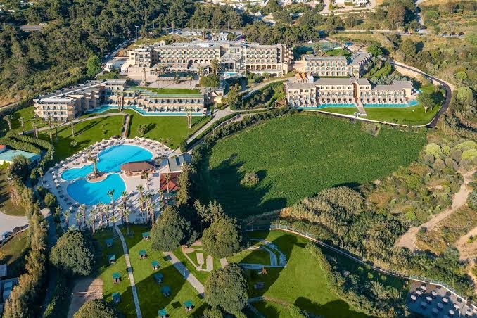 Kresten Palace Hotel panorāmas skats no putna lidojuma Rodas salā — plaša teritorija ar baseiniem, dārziem un viesnīcas korpusiem piekrastē