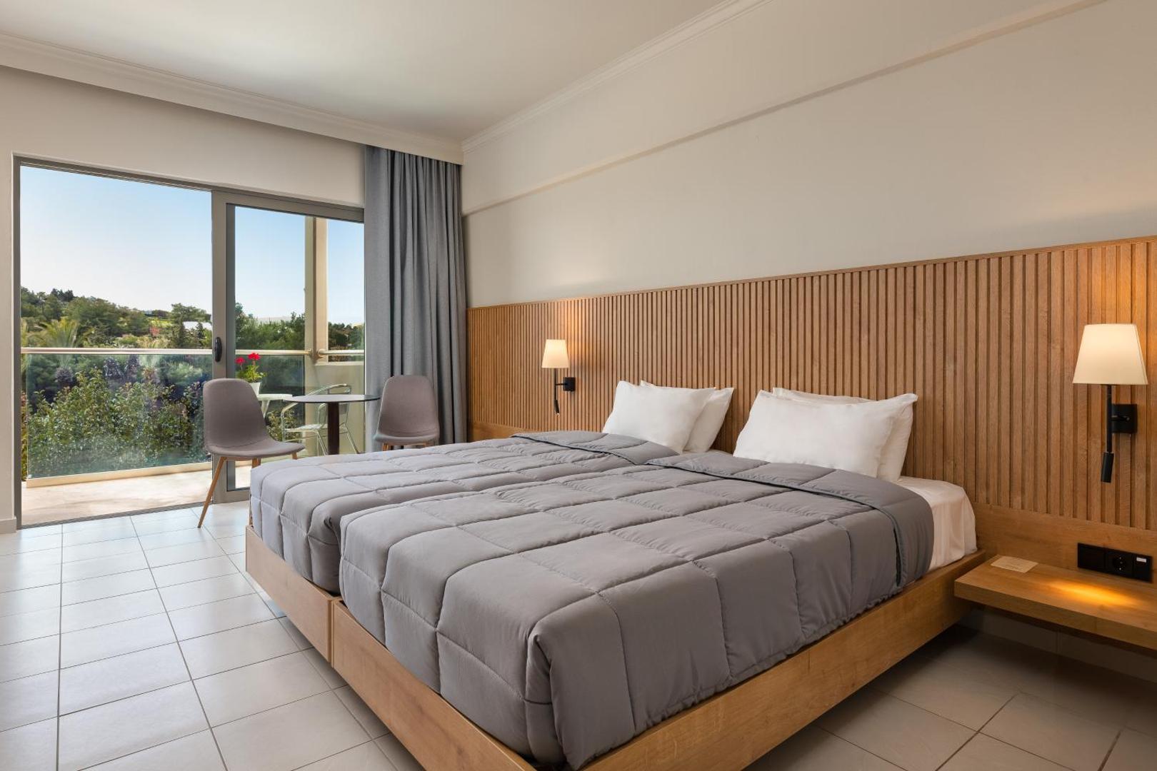 Kresten Palace Hotel gaišs divvietīgs numurs ar koka apdari, balkonu un skatu uz dārzu Rodas salas kūrortā