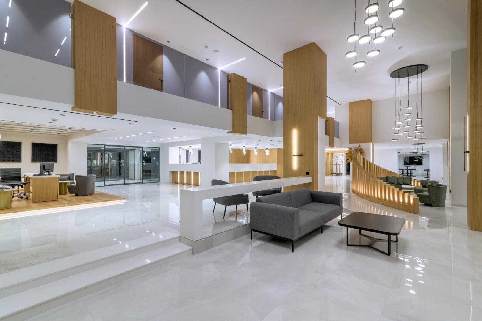 Sun Beach Resort plašais un modernais lobby vestibils ar atpūtas zonu, dīvāniem un recepcijas galdiem Rodas viesnīcā.