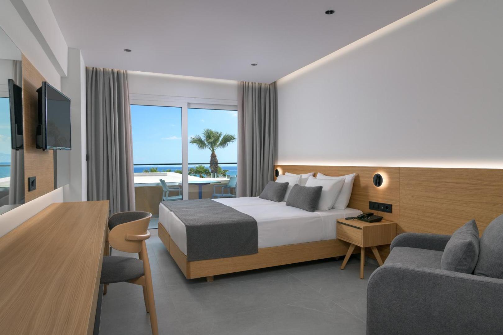 Sun Beach Resort moderns divvietīgs numurs ar koka apdari, pelēkiem akcentiem un balkonu, no kura paveras skats uz kūrorta teritoriju
