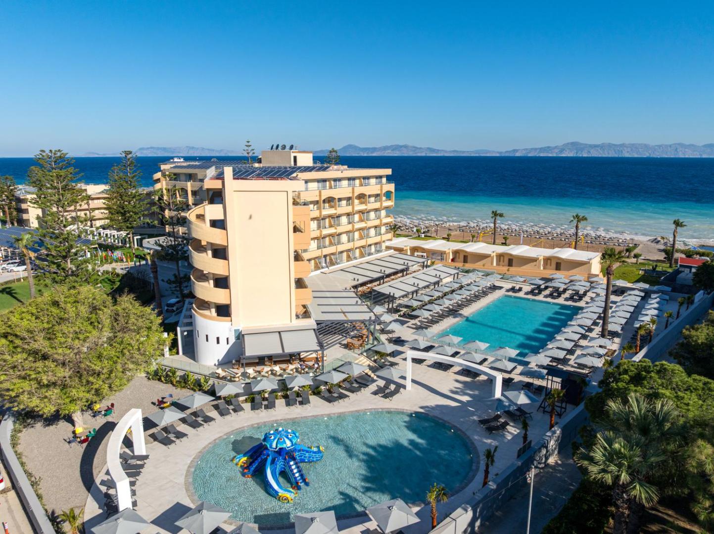 Sun Beach Resort Rodā skats no augšas uz galveno baseinu un bērnu baseinu ar astoņkāja slidkalniņu piekrastē