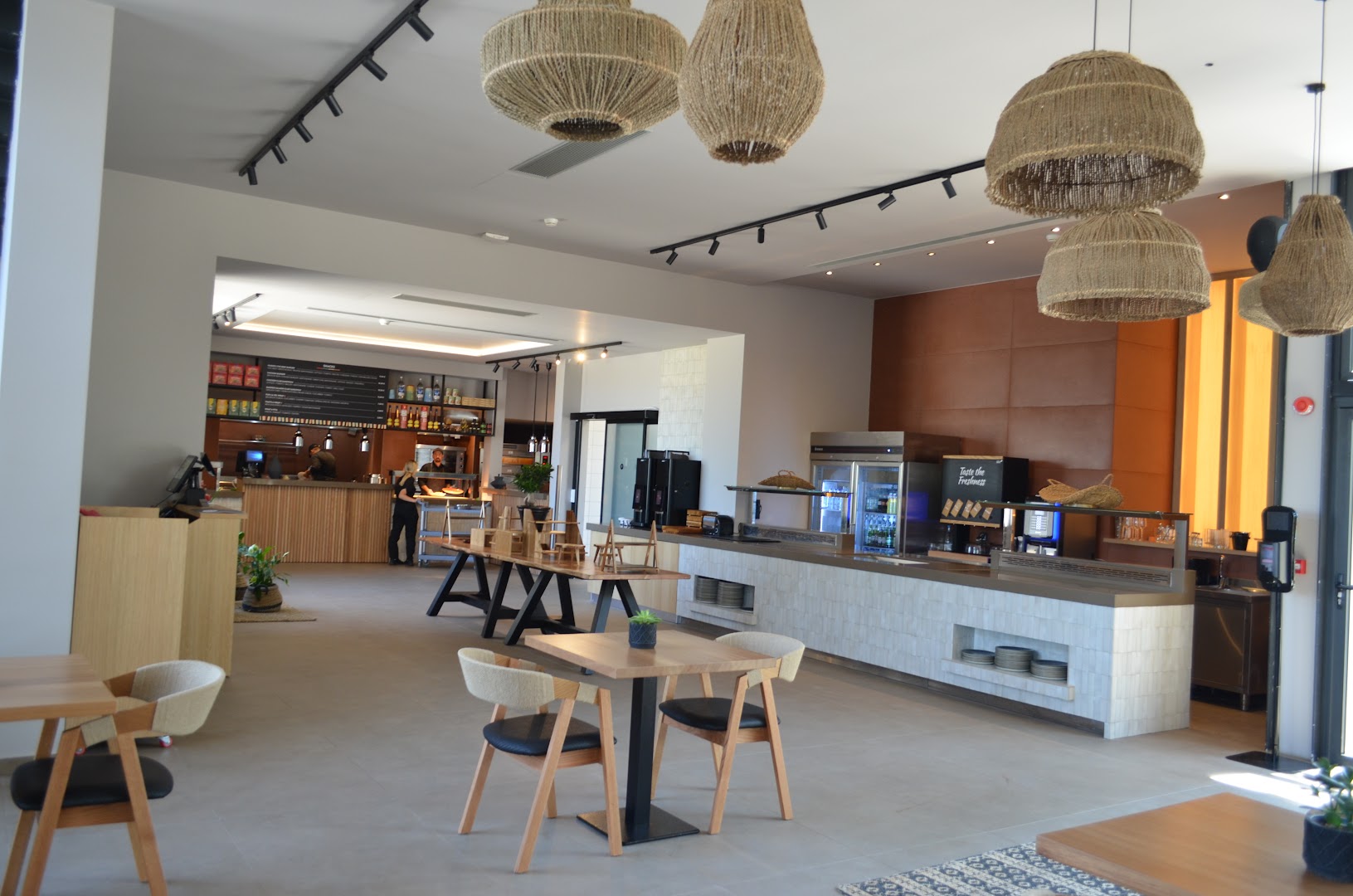 Cook's Club Ialysos Rhodes restorāna pašapkalpošanās zona ar modernu leti, dzērienu staciju un pītiem gaismas ķermeņiem