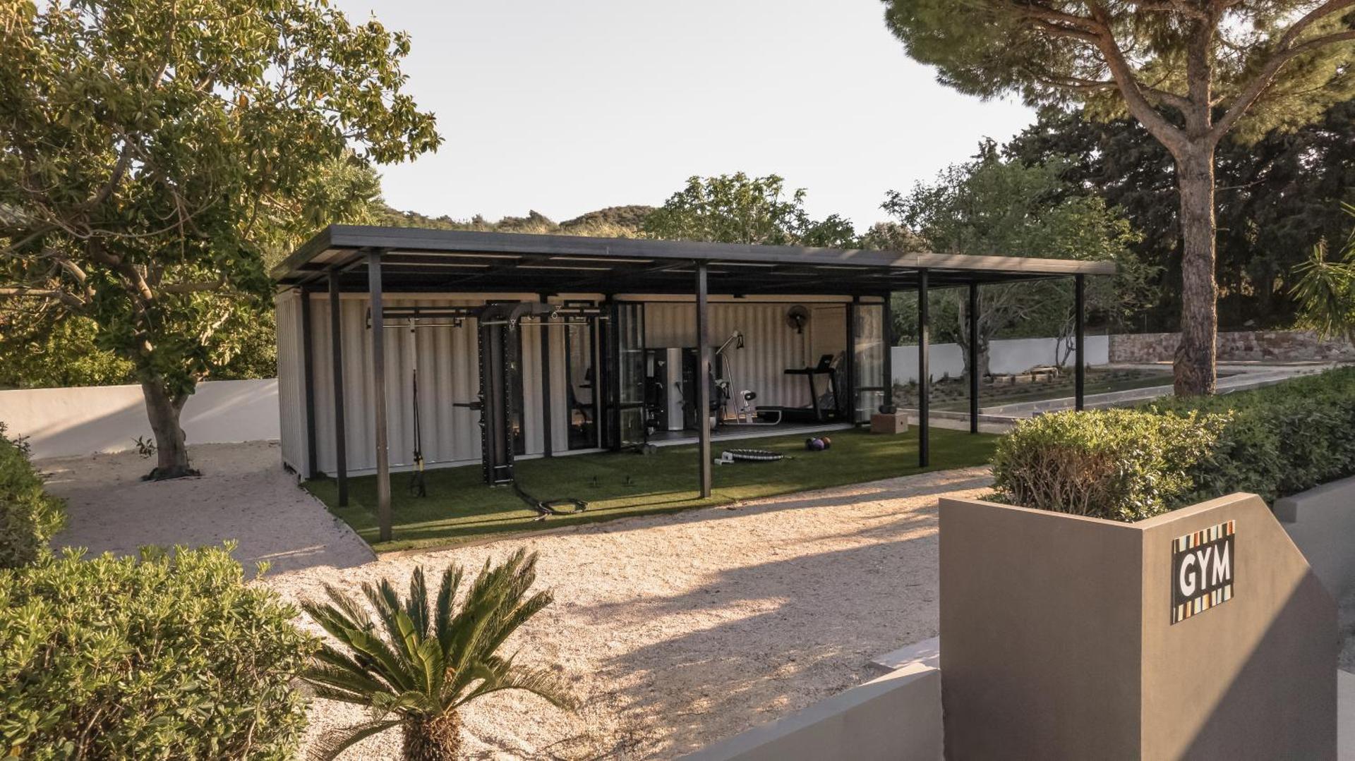 Cook's Club Ialysos Rhodes āra fitness zona modernā dizainā ar trenažieriem un mākslīgo zālienu Rodas salas dabas ielokā